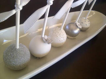 Noir Signature: Cake Pops. Sweet, bite-sized cake pops coated in glossy white chocolate with shimmering silver, offering a moist cake center and creamy finish for an elegant, indulgent treat. (₩10,000)