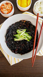Jjajangmyeon. Jjajangmyeon features thick, chewy noodles in a savory black bean sauce with a rich, caramel-like flavor.